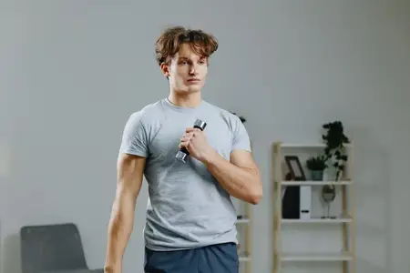Спортивный мужчина с рельефным прессом использует технологии для поддержания здоровья