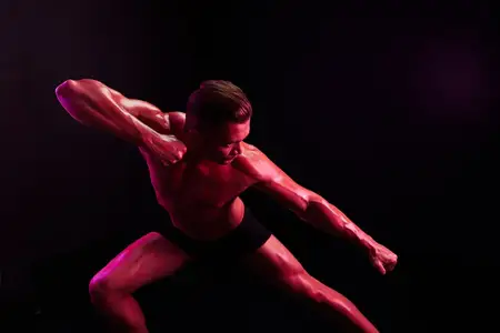 Профессиональные спортсмены-мужчины с обнаженным торсом в спортивной форме, изолированные на разноцветном фоне в неоновом свете