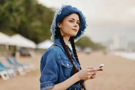 Стильная молодая женщина с красивыми волосами отдыхает на природе в городском парке, наслаждаясь красотой окружающего мира