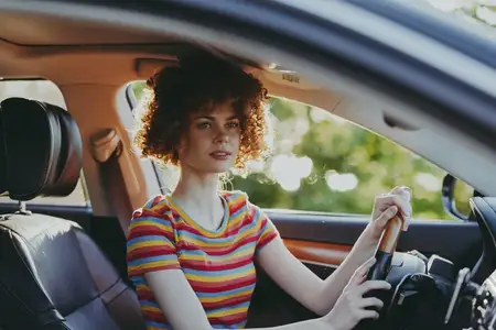 Вдохновлённая винтажем сцена с ярким солнечным светом, городской атмосферой и уверенным взглядом внутри автомобиля