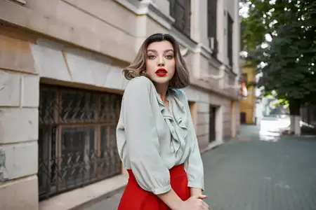 Весёлая блондинка на улице возле здания, прогуливается с эмоцией