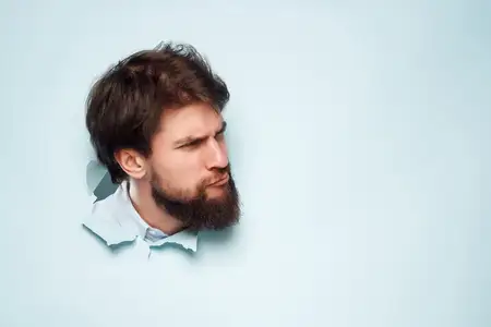 Эмоциональный мужчина выглядывает из-за фона