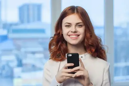 Женщина в рубашке с телефоном в руке; технологии, профессионализм