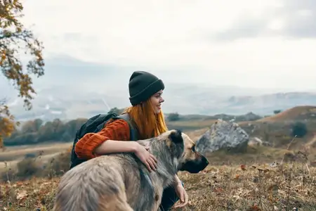 Женщина-туристка на природе рядом с собакой, пейзаж, путешествие