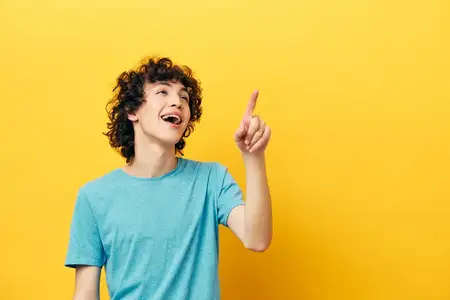 Веселый мужчина показывает большой палец вверх на желтом фоне