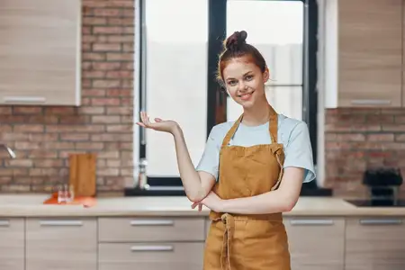Женщина находится в кухне квартиры, занимаясь домашними делами