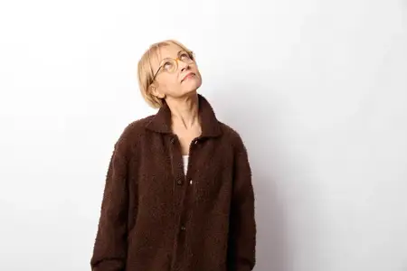 Женщина, пожилая, в очках и пальто, портрет, смотрит вверх, спокойная, студия, белый фон