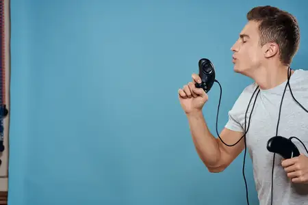 Мужчина с джойстиками, провода, технологии, игры, развлечения, досуг, веселье на синем фоне