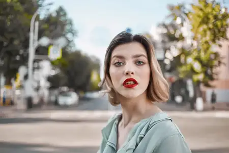 Красивая привлекательная женщина с красными губами прогуливается в парке, наслаждаясь свежим воздухом