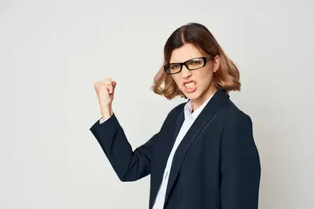 Деловая женщина в костюме жестикулирует рукой, выражая эмоции, в студии на работе