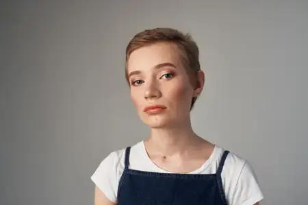 Весёлая женщина позирует, демонстрируя эмоции и забавную причёску