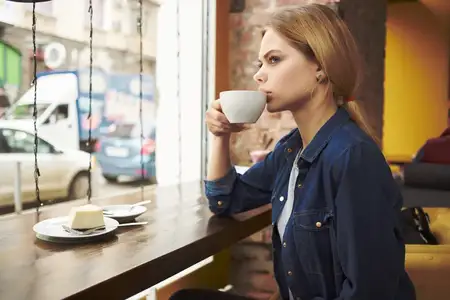 Красивая женщина с чашкой кофе отдыхает в кафе