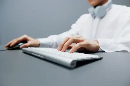 Менеджер в белой рубашке работает за клавиатурой в официальном офисе, стиль жизни и работа