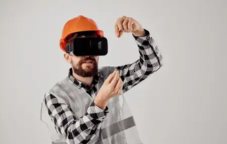 Строитель в оранжевой каске и 3D-очках жестикулирует руками