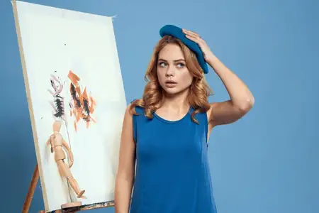 Женщина-художница с кистью и красками на мольберте