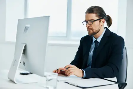 Мужчина в костюме, официальное лицо, работает за компьютером