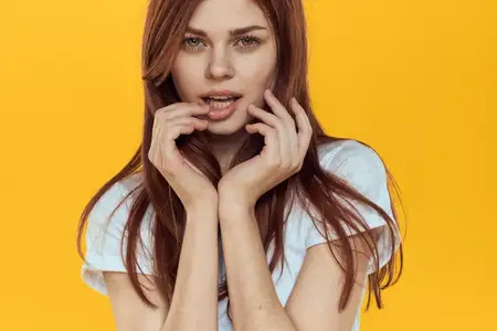 Красивая женщина в белой футболке, длинные волосы, гламур, крупный план, желтый фон