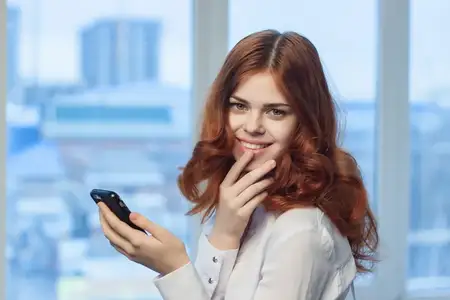 Женщина-менеджер с телефонами в руках, общение, офисная работа