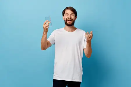 Бородатый мужчина с бокалом воды в студии