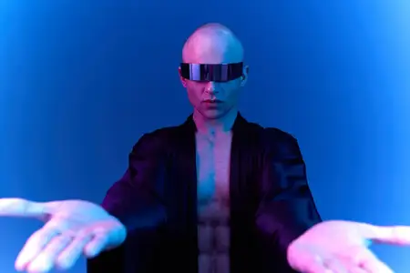 Это черно-белое изображение представляет мужчину в футуристических очках, который драматично позирует с вытянутыми руками, воплощая чувство силы и новаторства