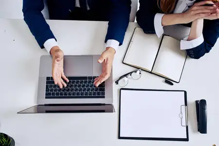 Деловая команда из мужчины и женщины работает вместе в офисе за ноутбуком