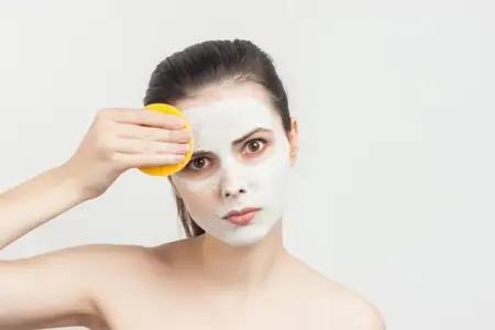 Красивая брюнетка с обнажёнными плечами, крем для лица, уход за кожей