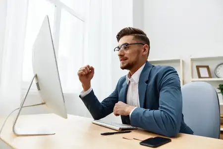 Мужчина в костюме работает за компьютером на рабочем столе, излучая уверенность в себе на изолированном фоне