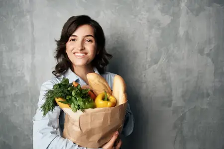Женщина в синей рубашке с пакетом продуктов в супермаркете, еда, диета