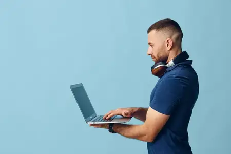 Молодой мужчина пользуется ноутбуком, работает в интернете, бизнесмен печатает