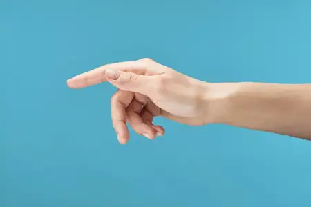 На крупном плане изображена женская рука, ухаживающая за кожей с помощью крема, на синем фоне