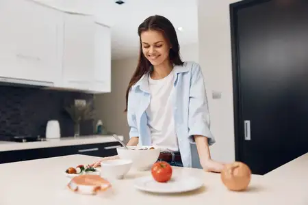 Женщина готовит здоровую еду из свежих овощей на современной кухне