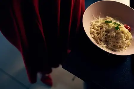 Вкусное блюдо на тарелке и ткань красного платья, вид сверху