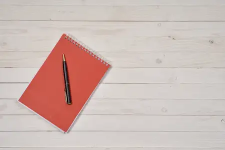 Блокнот, ручка, письменный стол, канцелярские принадлежности