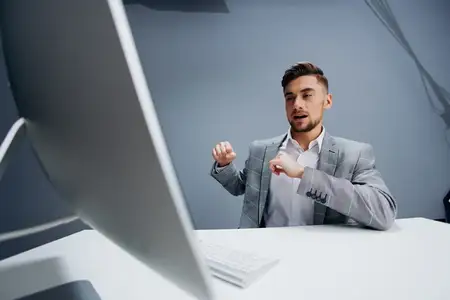 Менеджер работает за компьютером в офисе, используя современные технологии