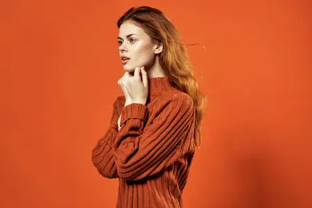 Симпатичная женщина в красных серьгах, украшения, косметика, позирует