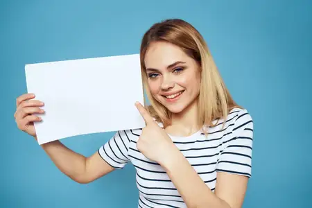 Женщина держит лист бумаги, на ней полосатая футболка