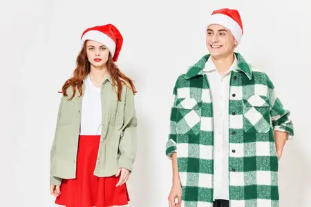 Привлекательная пара в праздничных колпаках на светлом фоне, обрезанный вид