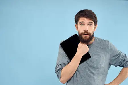 Эмоциональный мужчина с планшетом в руках, беспроводное устройство, интернет-технологии, образ жизни, синий фон