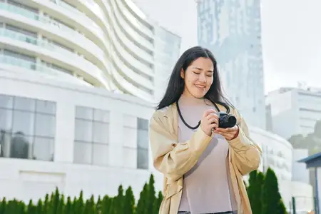 Женщина занимается городской фотосъемкой, наслаждаясь городскими пейзажами на открытом воздухе