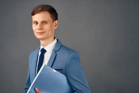 Красивый бизнесмен в костюме сложил руки перед собой во время работы в офисе