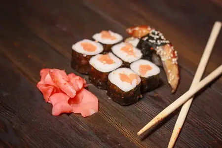 Роллы суши на деревянном столе, морепродукты, рыбная начинка, васаби и имбирь