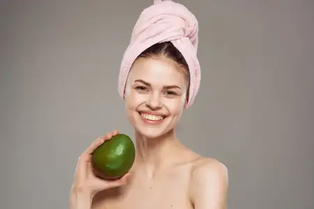 Женщина с полотенцем на голове, чистая кожа, в руке манго