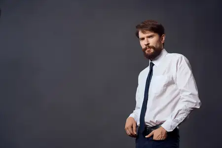 Мужчина в костюме демонстрирует эмоции и жестикулирует руками в студии