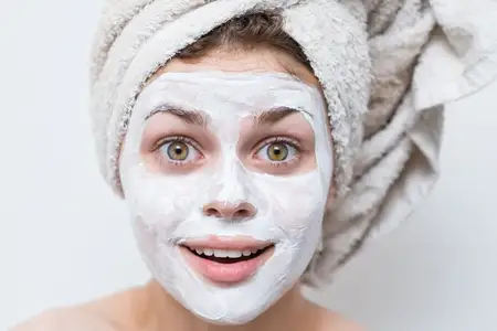 Женщина с маской для лица, уход за кожей, крупный план, улыбка