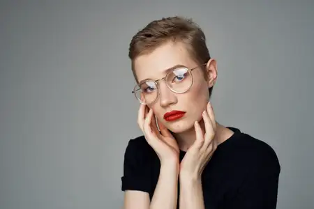 Коротко стриженная женщина в очках на изолированном фоне