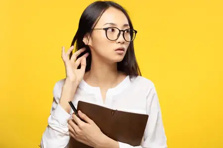Элегантная женщина с блокнотом в руках, официальный офис, жёлтый изолированный фон