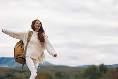 Улыбающаяся женщина стоит на скале