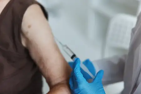 Врач делает инъекцию в руку