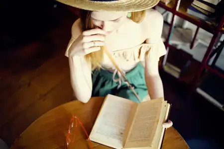 Весёлая женщина читает книгу в кафе, общаясь