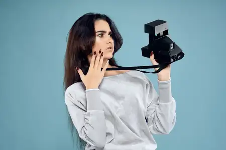 Женщина-фотограф с камерой на синем фоне